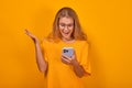 Young cheerful Caucasian woman with mobile phone is delighted to read news