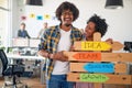 Young cheerful colleagues are enjoying posing for a photo while promoting company slogans in the office. Employees, job, office Royalty Free Stock Photo