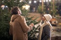 A young cheerful couple enjoying snow and christmas tree in the city. Christmas tree, love, relationship, Xmas, snow Royalty Free Stock Photo