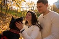 Young cheerful couple walking their dog in the park Royalty Free Stock Photo