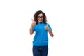 young cheerful curly woman with black hair dressed in a blue corporate t-shirt with print mockup