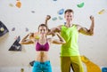 Young cheerful female and male rock climbers flexing biceps Royalty Free Stock Photo