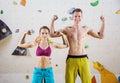 Young cheerful female and male rock climbers flexing biceps Royalty Free Stock Photo