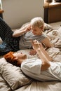 Gay couple listening music with earphones and mobile phone while laying on bed Royalty Free Stock Photo