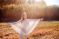 Cheerful girl with raised hands on the field in warm autumn season. Royalty Free Stock Photo