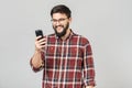 Young cheerful guy in headphones smiling holding phone listening to music Royalty Free Stock Photo