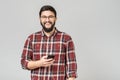 Young cheerful guy in headphones smiling holding phone listening to music Royalty Free Stock Photo