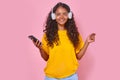 Young cheerful Indian millennial woman listening to favorite music in headphones Royalty Free Stock Photo