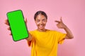 Young cheerful Indian woman teenager demonstrates mobile phone stands in studio Royalty Free Stock Photo