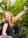 Young cheerful joyful smiling gorgeous woman holding up keys to her first new car. Customer satisfaction Royalty Free Stock Photo