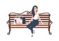 Young cheerful long haired women dressed in elegant clothes sitting on bench beside bags with purchases and relaxing