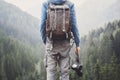 Young cheerful man photographer holding digital camera in a mountains. Photography, travel and active lifestyle c