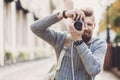 Young cheerful man photographer taking pictures with camera Royalty Free Stock Photo