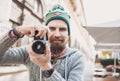 Young cheerful man photographer taking pictures with camera Royalty Free Stock Photo