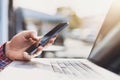 Young man texting on his smartphone in the city. Close up of cheerful adult using mobile phone in a cafe Royalty Free Stock Photo