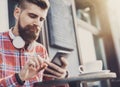 Young man texting on his smartphone in the city. Close up of cheerful adult using mobile phone in a cafe Royalty Free Stock Photo