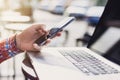 Young man texting on his smartphone in the city. Close up of cheerful adult using mobile phone in a cafe Royalty Free Stock Photo