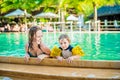 Young cheerful mother and son in a swimming pool
