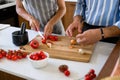 Happy multiethnic couple preparing home made tomato and basil pasta. Cooking at home