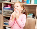 Young cheerful preschool girl wiping her mouth with a wet tissue after eating, smiling. Hygiene and tidyness childhood concept