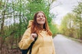 Young cheerful redhaired woman enjoying spring day in park. Young woman hiking and going camping in nature. Person with