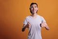 Young cheerful smiling asian man standing with thumbs up Royalty Free Stock Photo