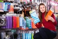 Young woman is choosing new curlers in hair care store. Royalty Free Stock Photo