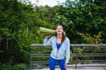 Young woman walking in urban park holding fitness rug. Royalty Free Stock Photo