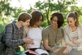 Young cheerful students sitting and studying outdoors Royalty Free Stock Photo