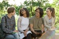 Young cheerful students sitting and studying outdoors Royalty Free Stock Photo