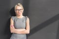 Young cheerful teacher standing in front of blackboard with arms crossed Royalty Free Stock Photo