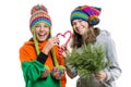 Young cheerful teenage girls having fun with Christmas candy canes, in winter knitted caps, isolated on white background Royalty Free Stock Photo