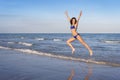 Young cheerful woman in bikini jumping on the beach. Royalty Free Stock Photo