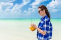 Young cheerful woman with coconut against turquoise sea Royalty Free Stock Photo
