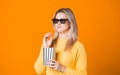 Young cheerful woman in 3D glasses watching a movie and eating popcorn. Royalty Free Stock Photo