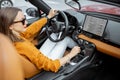 Woman driving sports car with a digital touchscreen