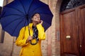 A young cheerful woman is listening to the music while walking the city on a rainy day. Walk, rain, city Royalty Free Stock Photo