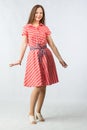 Young cheerful woman in red dress in studio