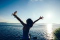 Woman jogger open arms at sunrise seaside Royalty Free Stock Photo