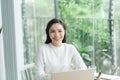 Young cheery happy positive cute beautiful business woman sit indoors in office using laptop computer Royalty Free Stock Photo