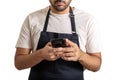Young chef with black apron using a mobile on white background Royalty Free Stock Photo