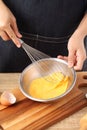 Young chef cooking omelet on wooden table Royalty Free Stock Photo