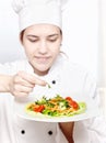 Young chef decorating delicious salad