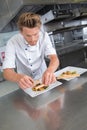 Young chef garnishing dish Royalty Free Stock Photo