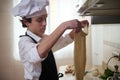 Young Chef Makes Flat Dough Sheet In Bright Kitchen, Focusing On Culinary Craft Royalty Free Stock Photo
