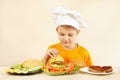 Young chef puts cheese on hamburger