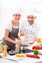 Young chef training a young attractive girl to cook Royalty Free Stock Photo