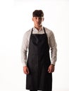 Young chef or waiter posing, wearing black apron and white shirt isolated Royalty Free Stock Photo