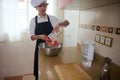 Young Chef In White Shirt And Black Apron Strains Mixture In Kitchen Bowl Royalty Free Stock Photo