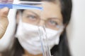 Young chemical female researcher holding two glass tubes